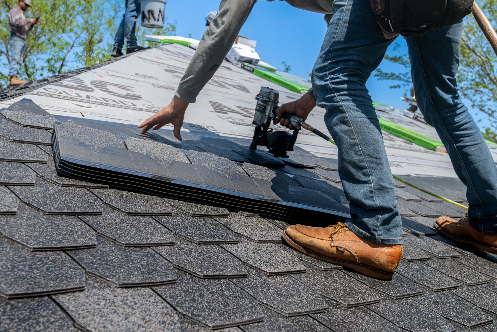 A roofer working on a house roof