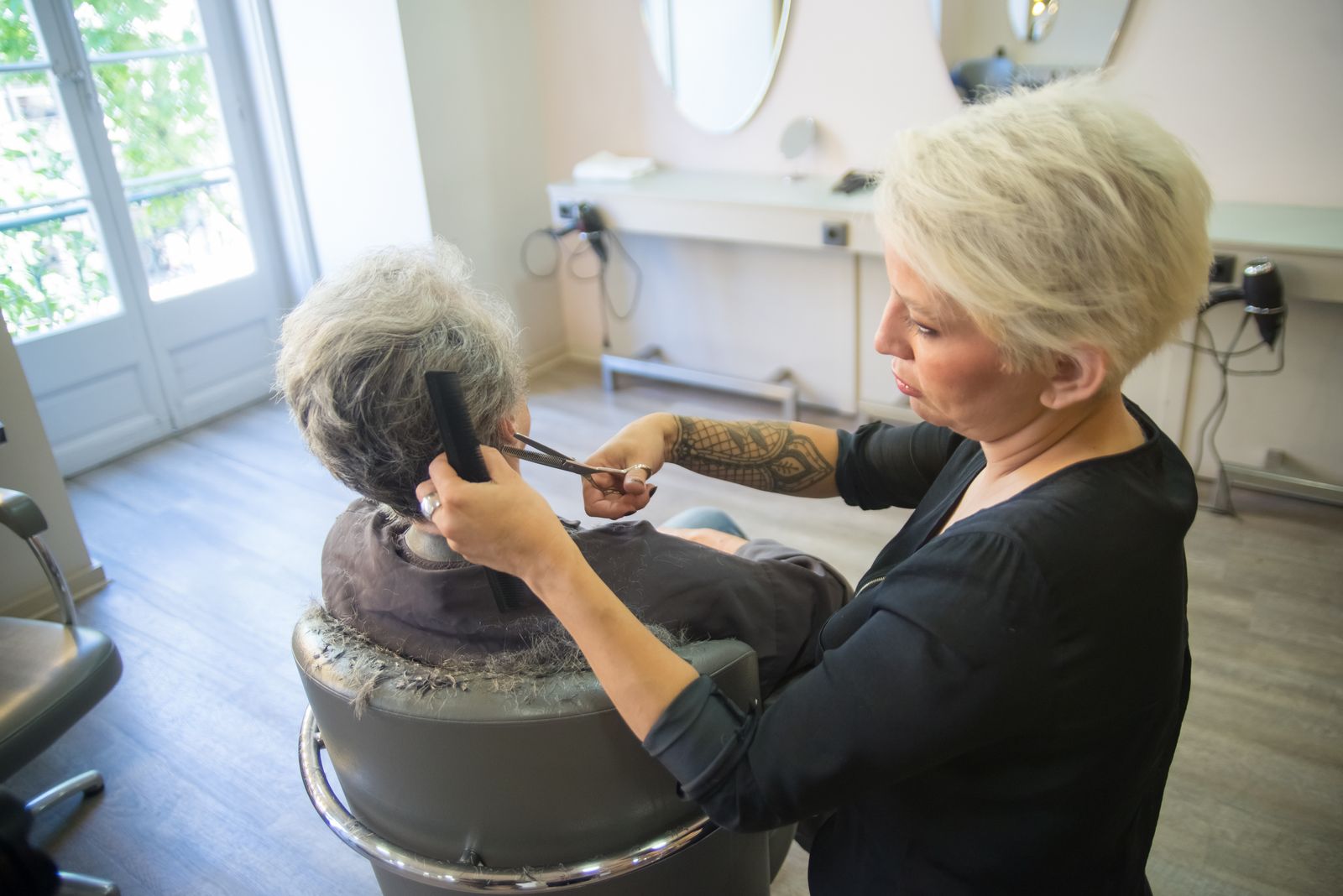 A stylist mid-cut with a client